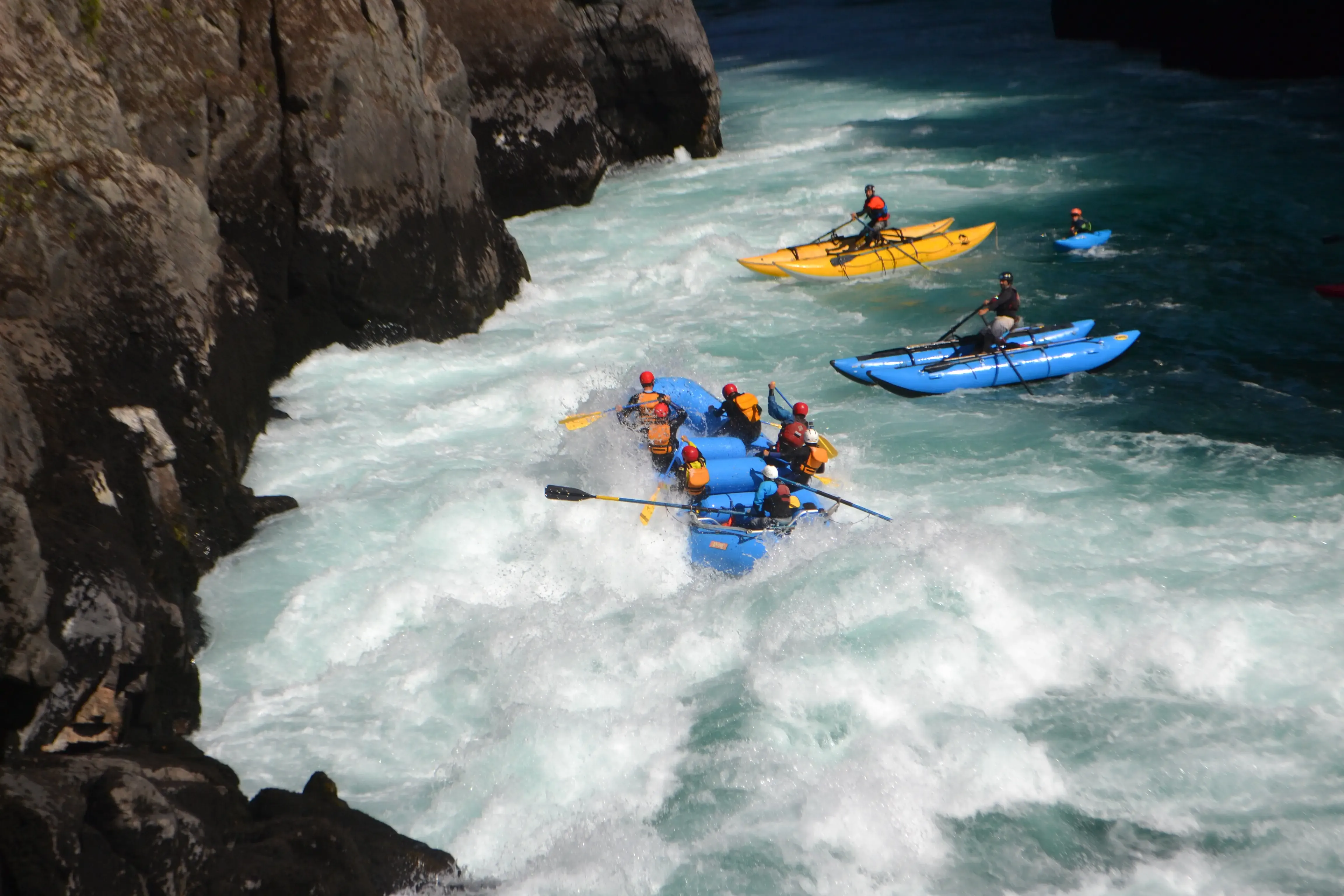 Botes de rafting bajando un rápido en el cañón